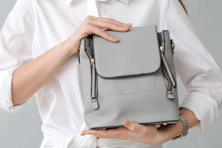 Beautiful woman with stylish bag on gray backgroundの写真素材