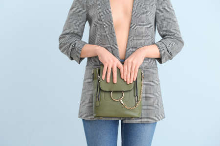 Beautiful woman with stylish bag on color backgroundの写真素材