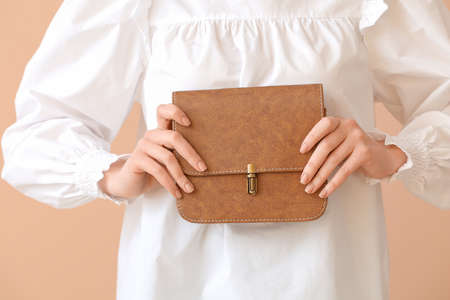 Beautiful woman with stylish bag on color backgroundの写真素材