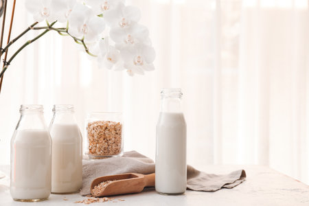 Bottles of tasty oat milk on tableの写真素材