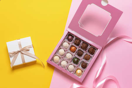 Box with delicious candies on color background
