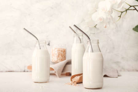 Bottles of tasty oat milk on tableの写真素材