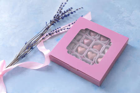 Box with delicious candies on color backgroundの写真素材