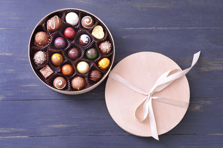 Box with delicious candies on dark wooden backgroundの写真素材