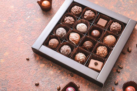 Box with delicious candies on color backgroundの写真素材