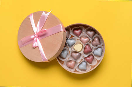 Box with delicious candies on color backgroundの写真素材