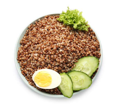 Plate with tasty buckwheat porridge, cucumber and eggs on white backgroundの写真素材