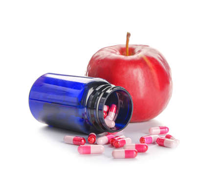 Bottle with weight loss pills and apple on white backgroundの写真素材