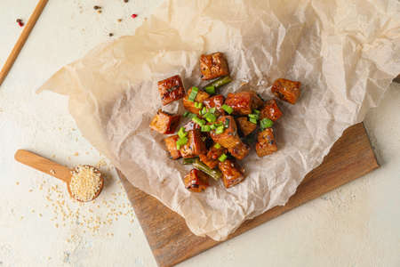 Board with tasty tofu cheese and vegetables on tableの写真素材