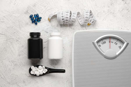 Weight loss pills, scales and measuring tape on light backgroundの写真素材