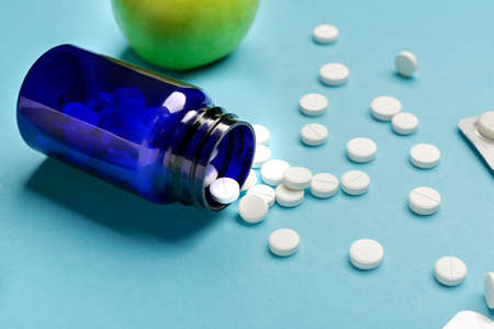 Bottle with weight loss pills on color backgroundの写真素材