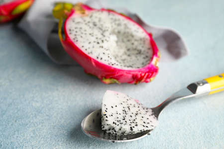 Tasty dragon fruit with spoon on color backgroundの写真素材