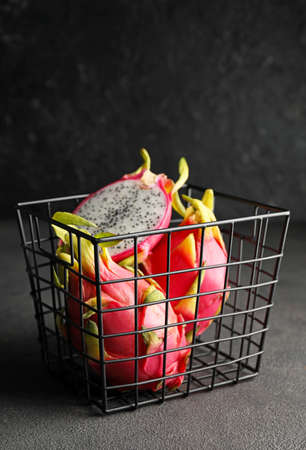 Basket with tasty dragon fruit on dark backgroundの写真素材