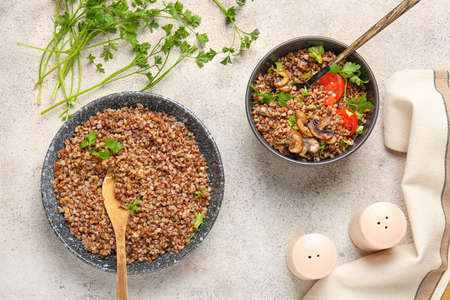 Bowls of tasty buckwheat porridge on gray backgroundの写真素材