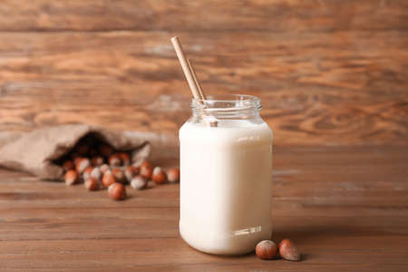 Jar of tasty hazelnut milk on tableの写真素材