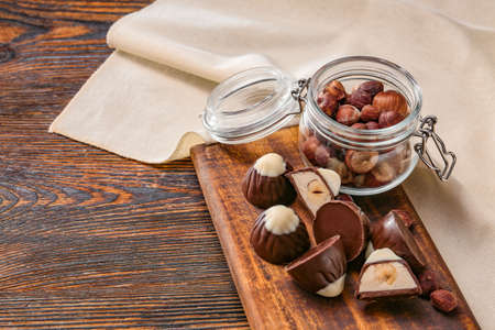 Tasty chocolate candies with hazelnuts on tableの写真素材