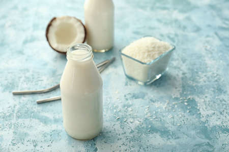 Bottle of tasty coconut milk on color backgroundの写真素材