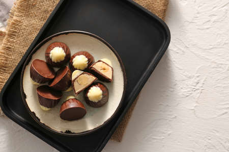Plate with tasty chocolate candies on white backgroundの写真素材