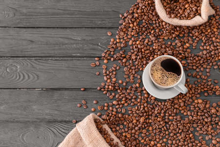 Cup of hot coffee and beans on wooden backgroundの写真素材