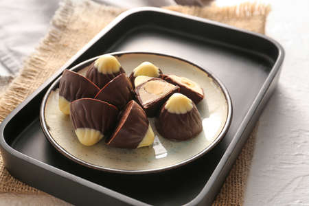 Plate with tasty chocolate candies on white backgroundの写真素材