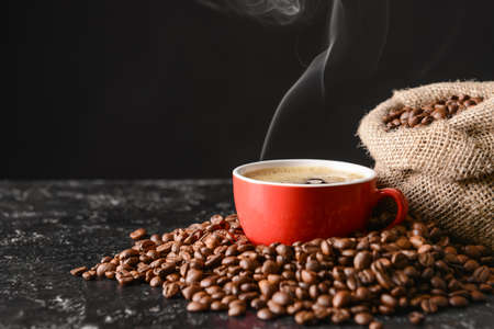 Cup of hot coffee and beans on tableの写真素材