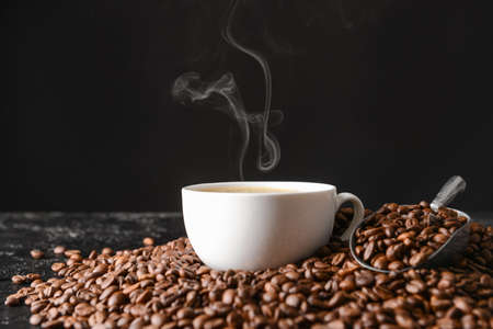 Cup of hot coffee and beans on tableの写真素材