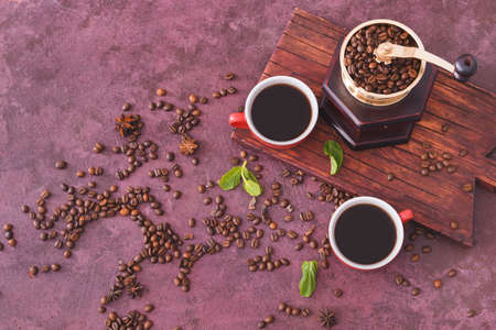 Composition with cups of hot coffee and beans on tableの写真素材