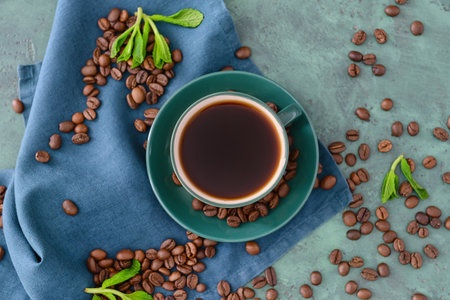 Cup of hot coffee and beans on tableの写真素材