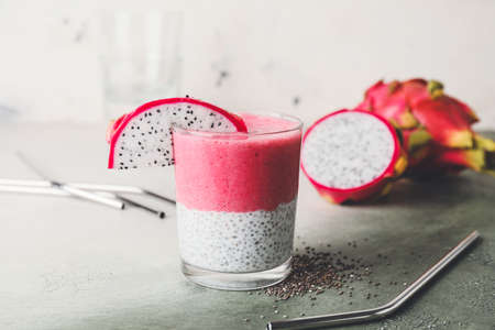 Glass of dragon fruit smoothie on color backgroundの写真素材