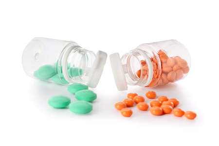 Bottles with different pills on white background