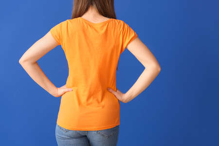 Young woman in stylish t-shirt on color backgroundの写真素材