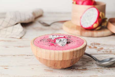 Bowl with dragon fruit smoothie on tableの写真素材