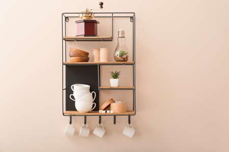 Shelf with cups on light wallの写真素材