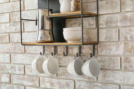 Shelf with kitchenware on brick wall