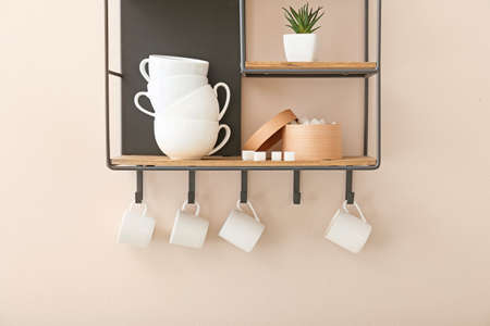 Shelf with cups on light wallの写真素材
