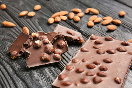 Sweet chocolate with nuts on wooden table