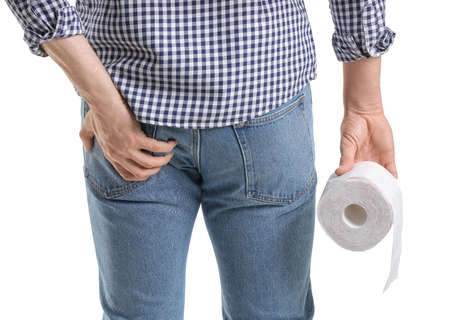 Young man suffering from hemorrhoids on white background