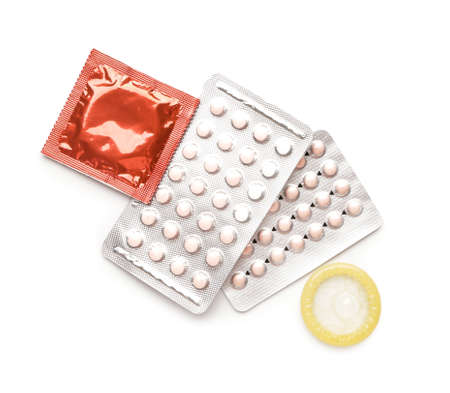 Contraceptive pills and condoms on white backgroundの写真素材