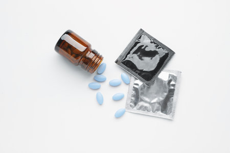 Bottle with sex pills and condoms on white backgroundの写真素材