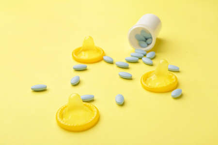 Bottle with sex pills and condoms on color backgroundの写真素材