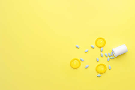 Bottle with sex pills and condoms on color backgroundの写真素材