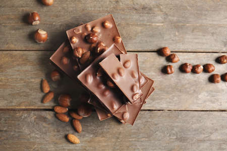 Sweet chocolate with nuts on wooden table