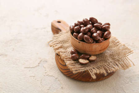 Bowl with tasty chocolate nuts on white backgroundの写真素材