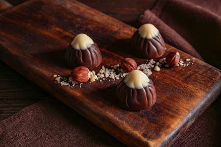 Tasty chocolate candies with nuts on table