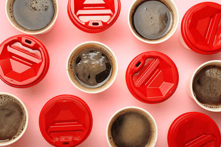 Many takeaway coffee cups on color background
