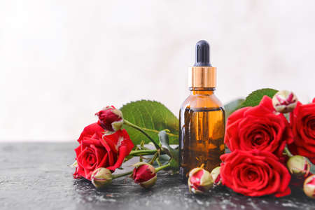 Bottle with rose essential oil on tableの写真素材