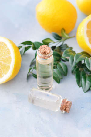 Bottles with lemon essential oil on color backgroundの写真素材