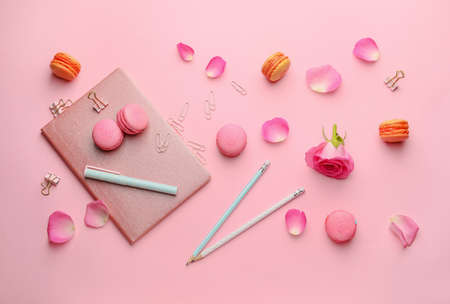 Stationery with tasty macarons on color backgroundの写真素材