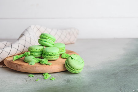 Board with tasty macarons on tableの写真素材