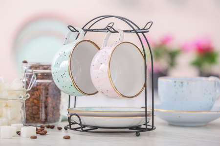 Holder with cups and saucers on kitchen tableの写真素材